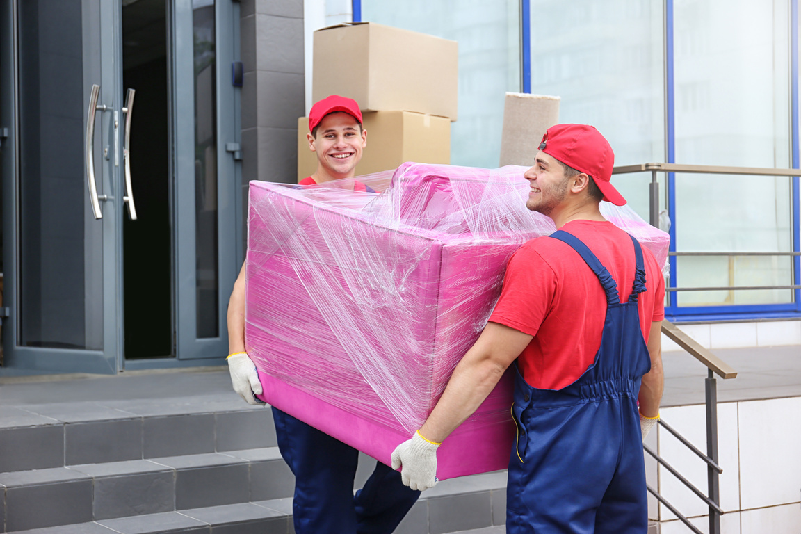 Two Male Workers Carrying  Pink Armchair