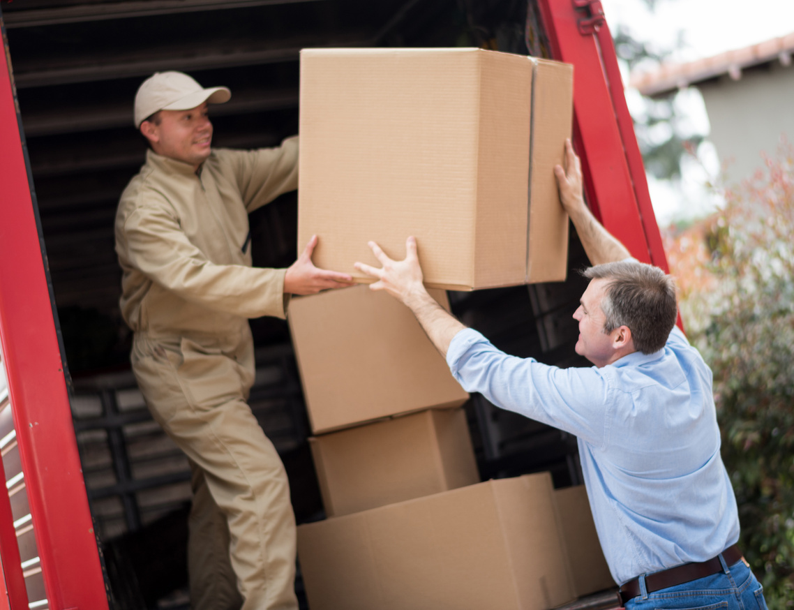 Man loading a moving truck with movers